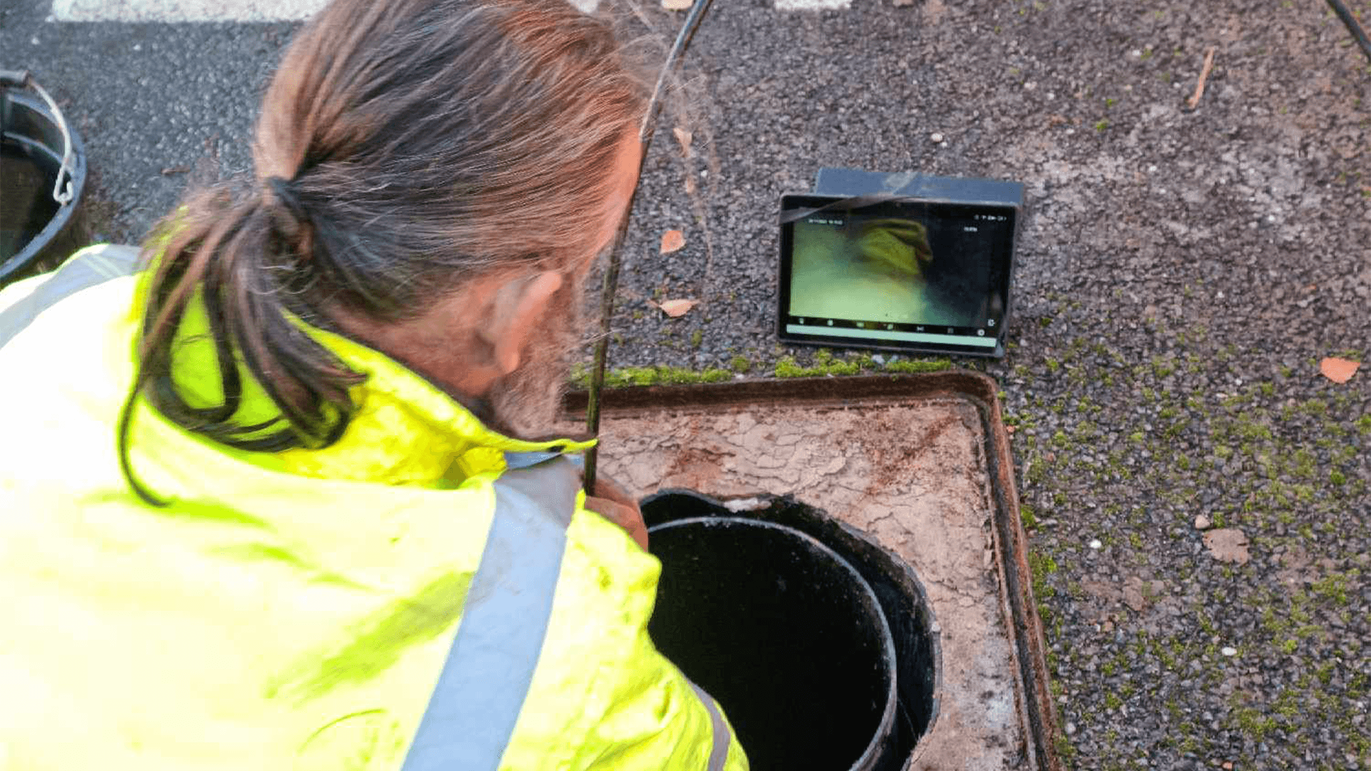 An drain surveyor using a CCTV drain inspection camera in a pipe system