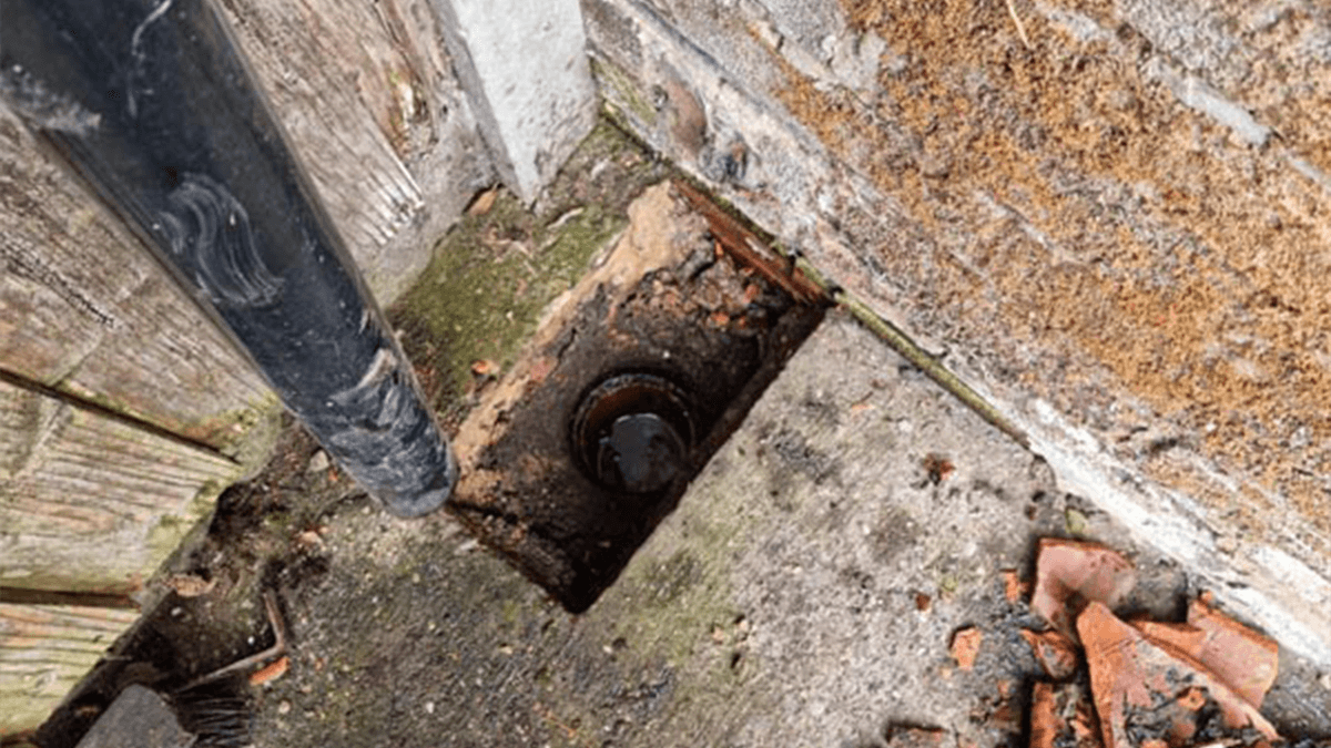 A photo of a engineer of a drain unblocking company unblocking a drain