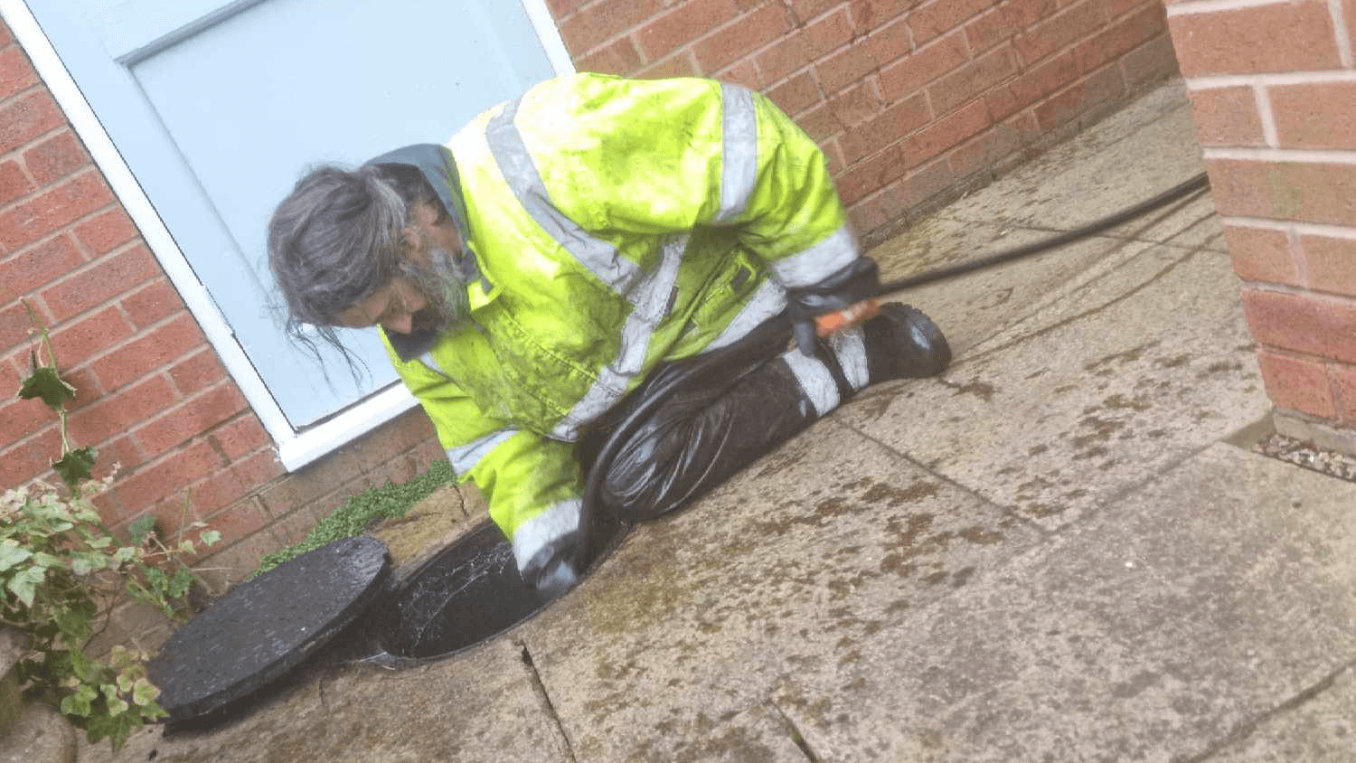 A photo of an emergency plumber performing a drain unblocking plumbing service.