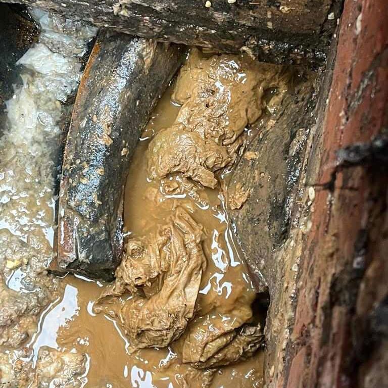 A Photo of a blocked sink due to food grease and food.